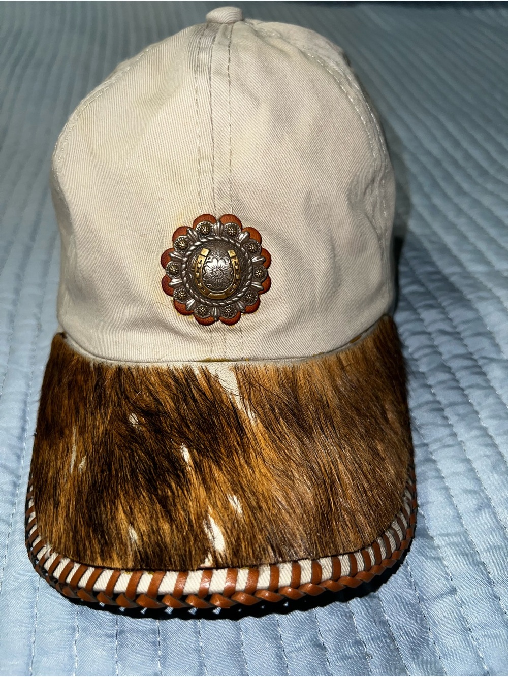 Tan cap with hair on hide brim and concho accent